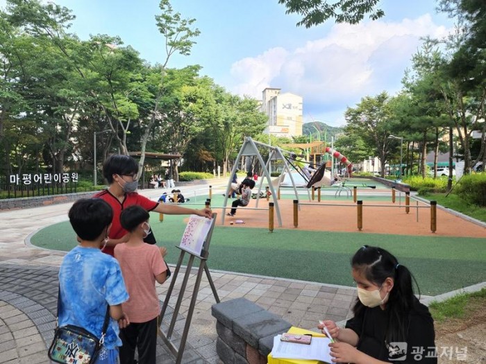 1. 마평어린이공원을 이용한 시민과 어린이들이 이용자 만족도 조사 패널에 스티커를 붙이고 있는 모습.jpg